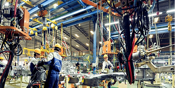 Linha de montagem industrial com ferramentas e cabos suspensos, aplicação de cabos para automação e ambientes industriais.