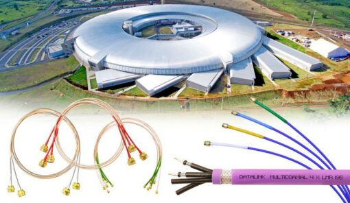 Moderno e tecnológico acelerador de partículas, chamado de Sirius. O Sirius tem uma estrutura circular com um telhado parcialmente aberto, cercado por estacionamentos e áreas verdes. Na parte inferior da imagem, há cabos elétricos multicoloridos e conectores dourados.