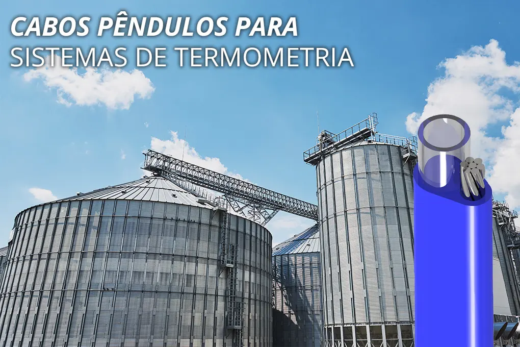 Silos metálicos industriais com estrutura de transporte de grãos. No primeiro plano, Cabo Agronegócio (Pêndulo) para sistemas de termometria.