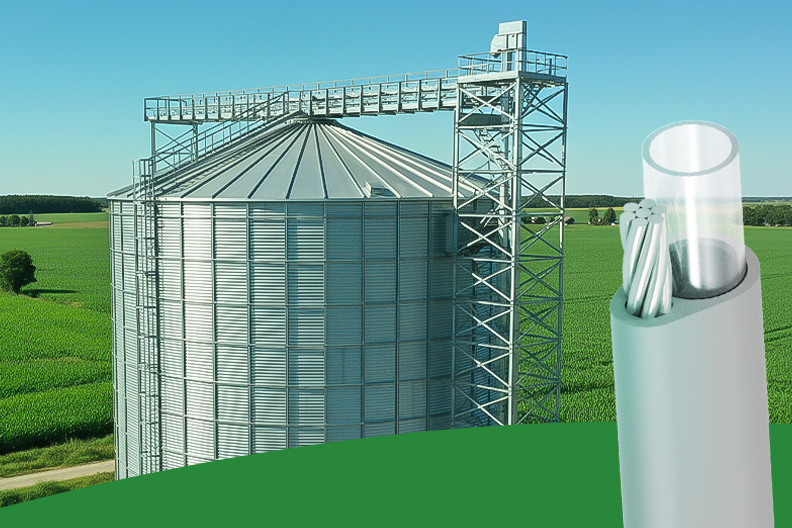 CABOS PÊNDULOS PARA SISTEMAS DE TERMOMETRIA Silos metálicos industriais com estrutura de transporte de grãos. No primeiro plano, Cabo Agronegócio (Pêndulo) para sistemas de termometria.