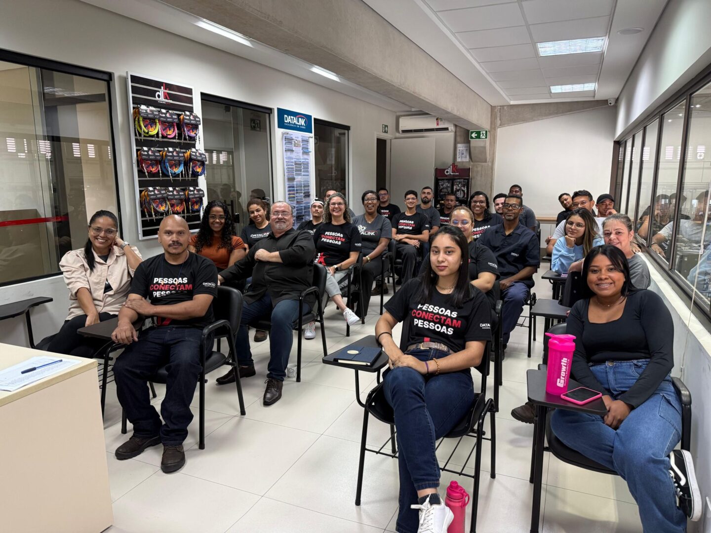 1776863896056 Group of diverse adults in a training room, seated in chairs and facing the camera with smiles.
